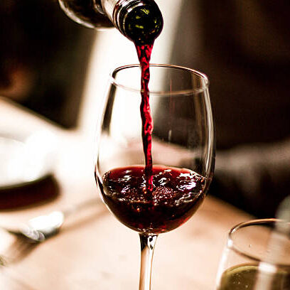 Wine Pouring into Glass Red wine being poured into a stem glass at the table. red wine stock pictures, royalty-free photos & images
